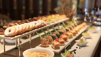 A buffet with various food items including pastries, desserts, and appetizers.