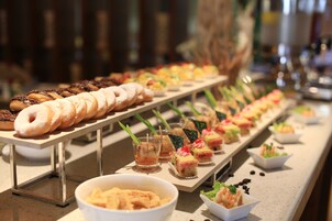 A buffet with various food items including pastries, desserts, and appetizers.