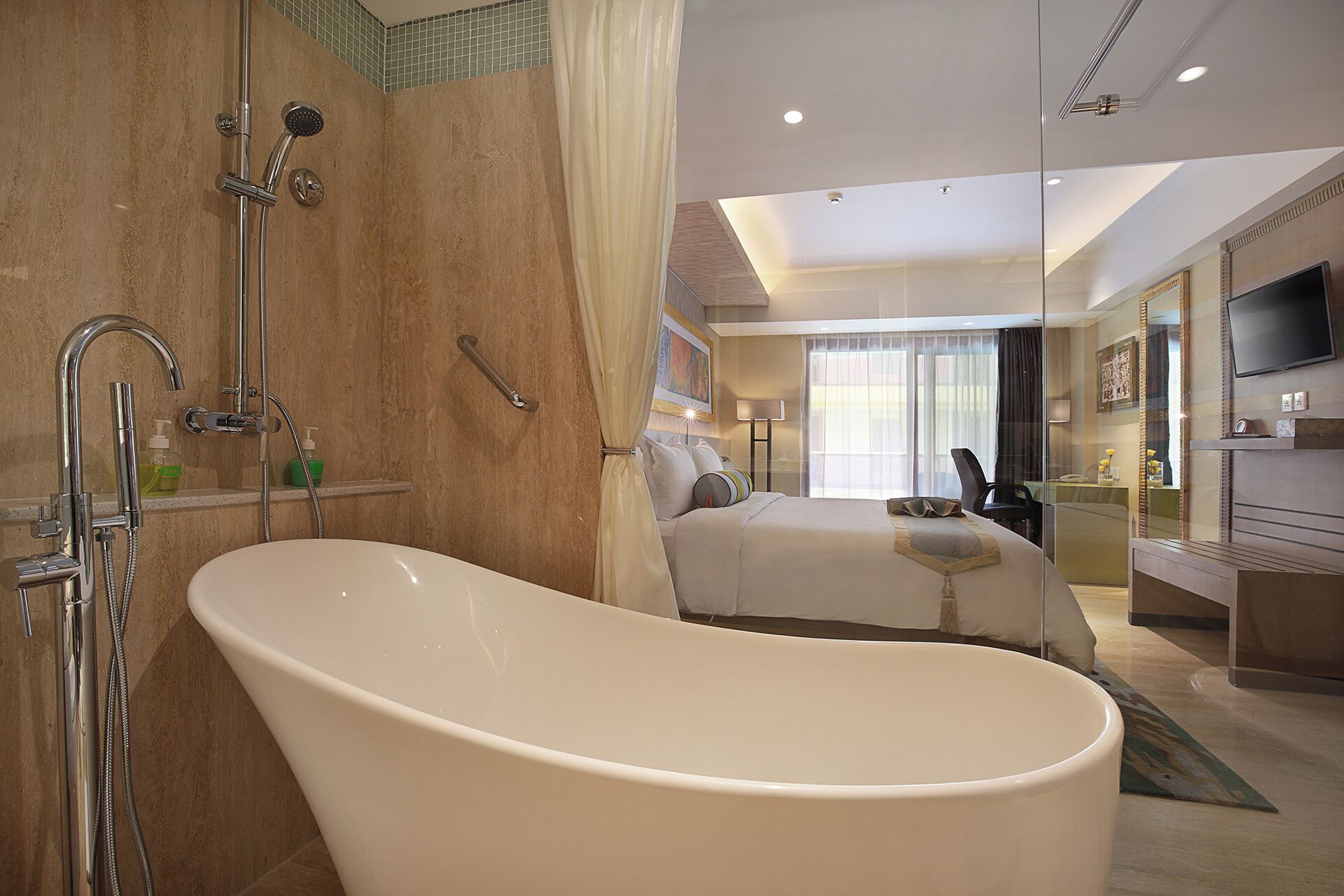 Een moderne hotelbadkamer met een vrijstaand bad, een douchegedeelte en een groot bed met uitzicht op de stad.