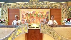 A reception desk with ornate wall decorations and a large painting above it. - SenS Hotel and Spa Conference Ubud Town Centre (Ubud)