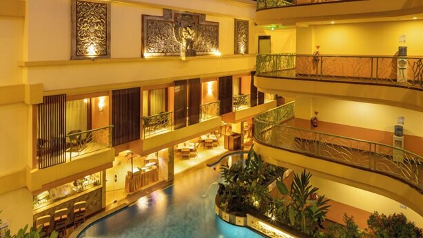 A multi-level hotel with a central swimming pool, balconies, and indoor plants. - SenS Hotel and Spa Conference Ubud Town Centre (Ubud)