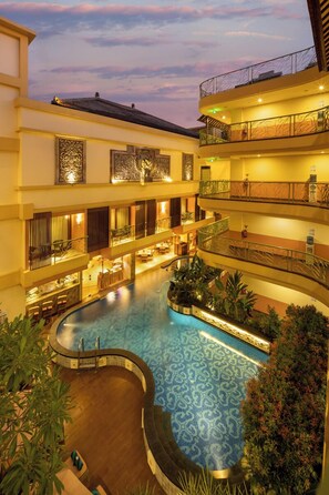 A multi-level hotel with a central swimming pool, balconies, and indoor plants. - SenS Hotel and Spa Conference Ubud Town Centre (Ubud)