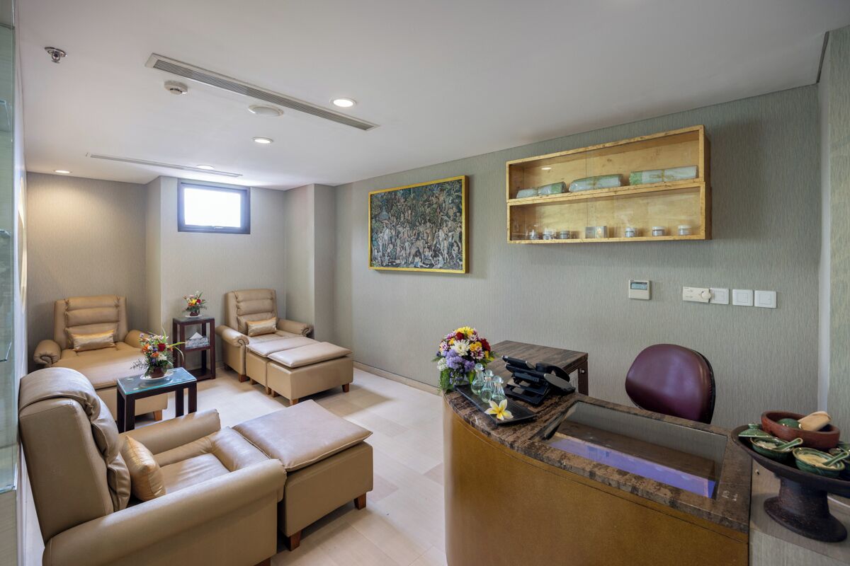 Un espace d’accueil comprenant un bureau, des chaises, une fenêtre, un tableau et des étagères avec divers objets.