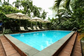 Una piscina al aire libre, tumbonas