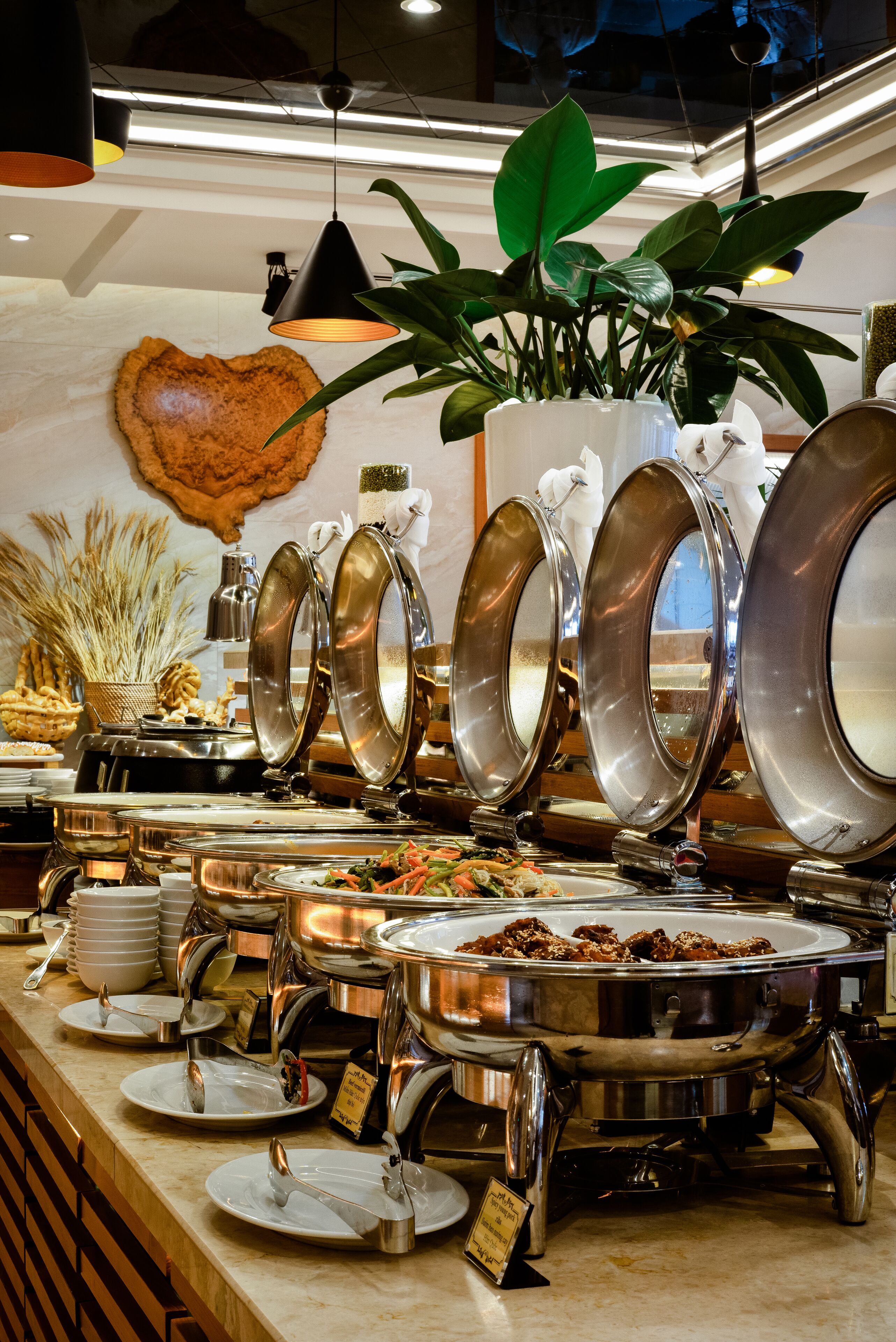 A buffet setup with multiple serving stations, including plates, bowls, and a variety of food items.