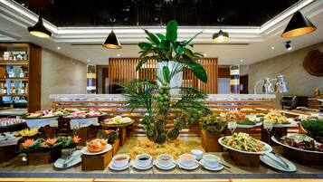 A buffet setup with various food items and a central decorative plant.