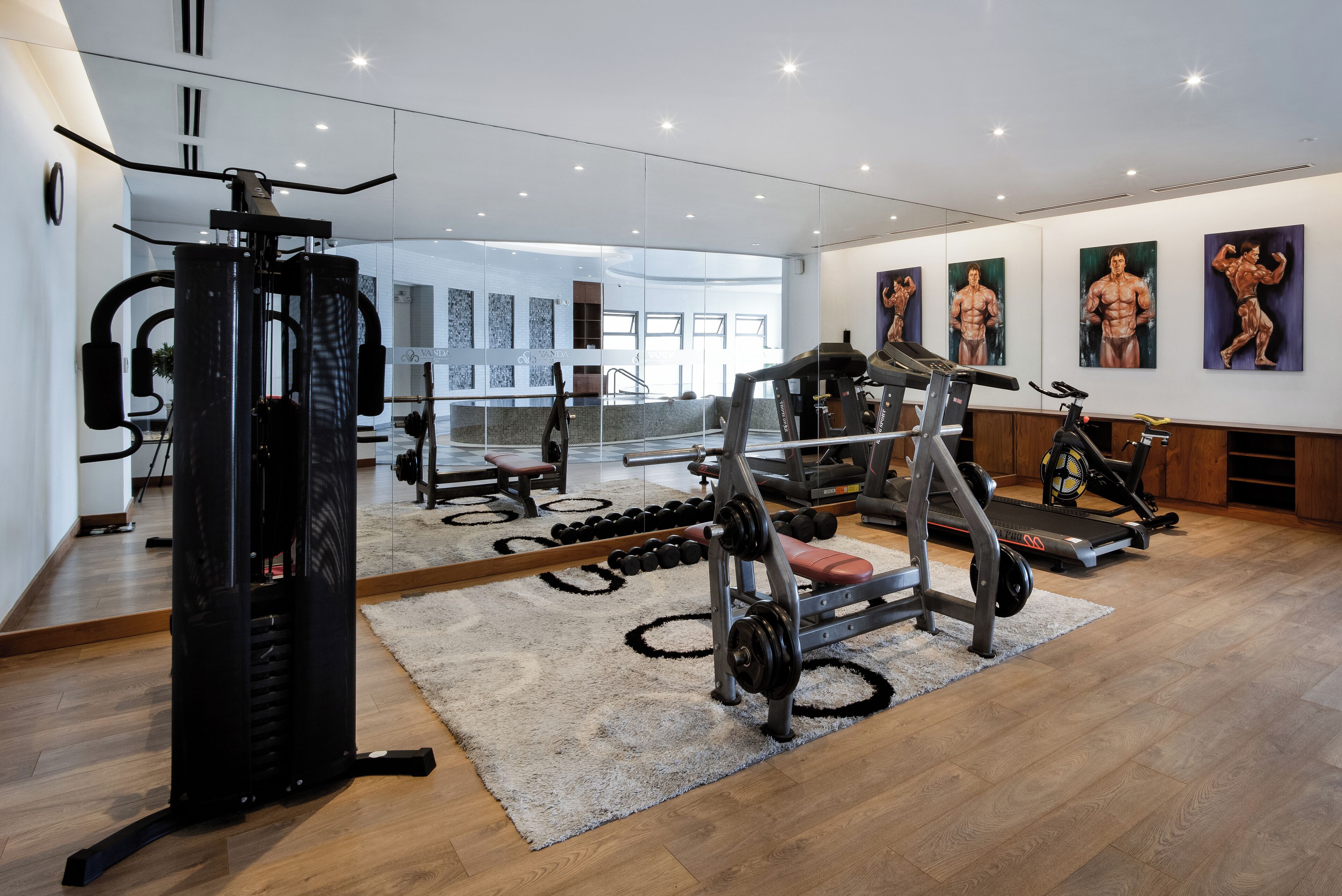 Una palestra moderna con attrezzature cardio, macchinari per pesi e manubri.