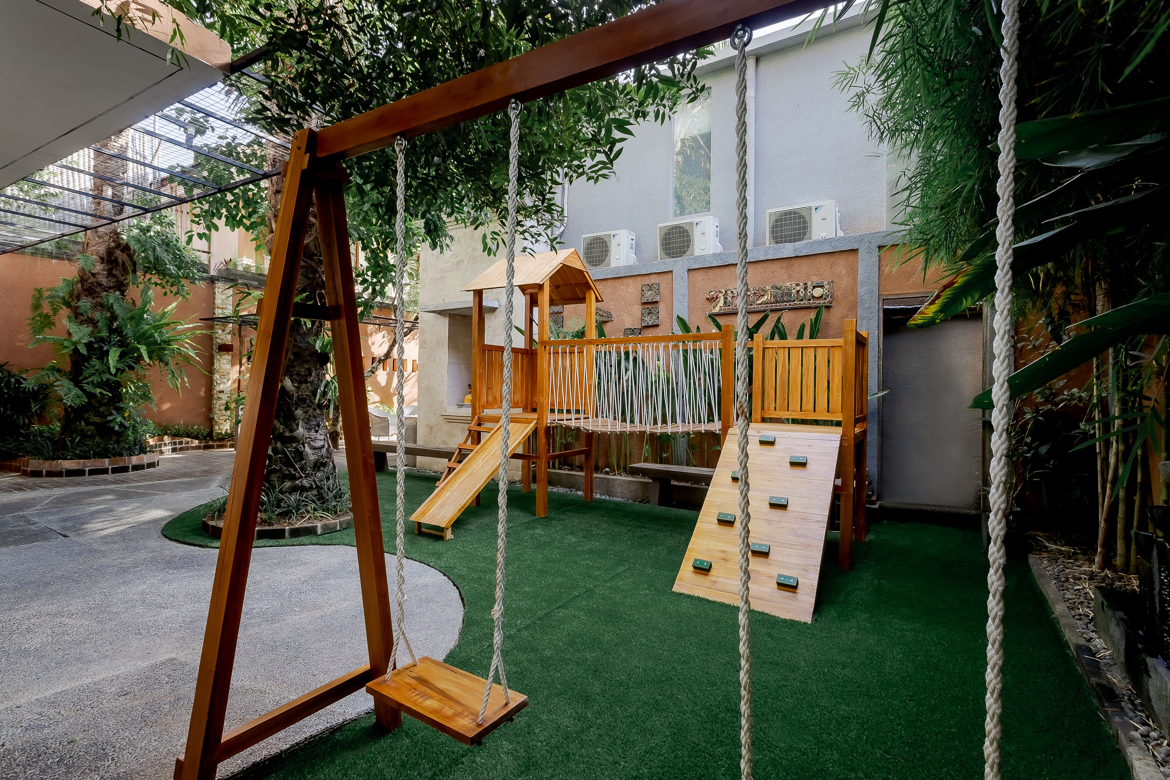 An indoor playground with a swing set, slides, and climbing structures.