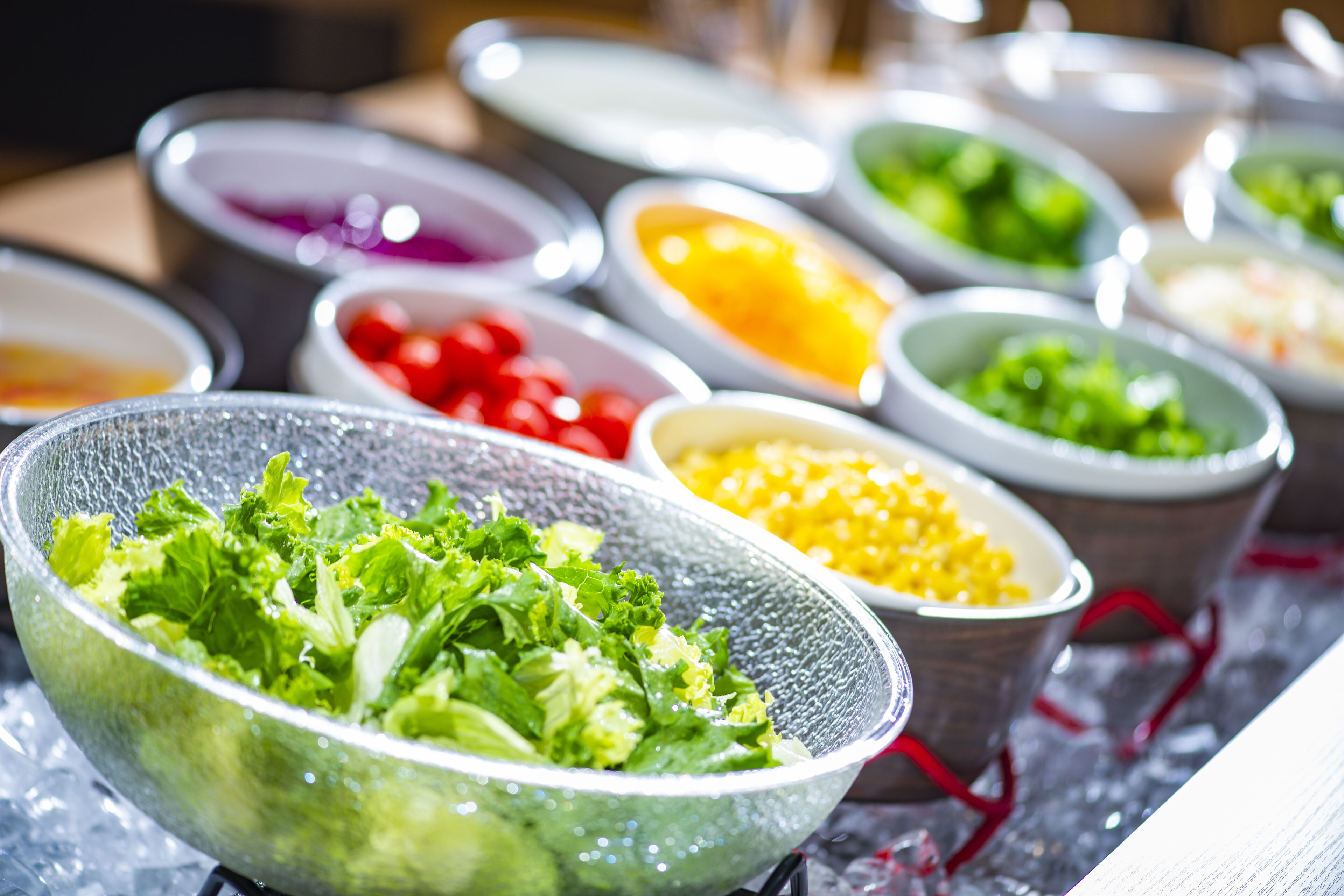 A variety of food items in bowls, including salads and other dishes.