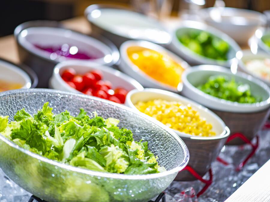 A variety of food items in bowls, including salads and other dishes.