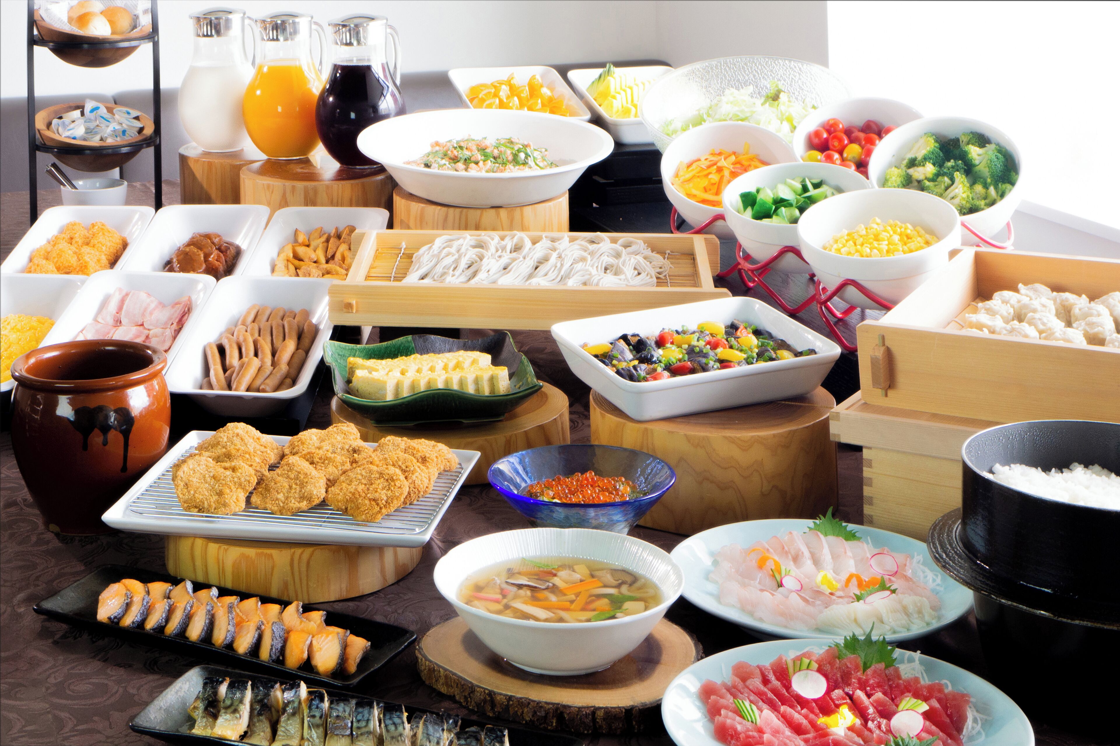 A variety of food items including sushi, bowls of soup, and a pot of rice.