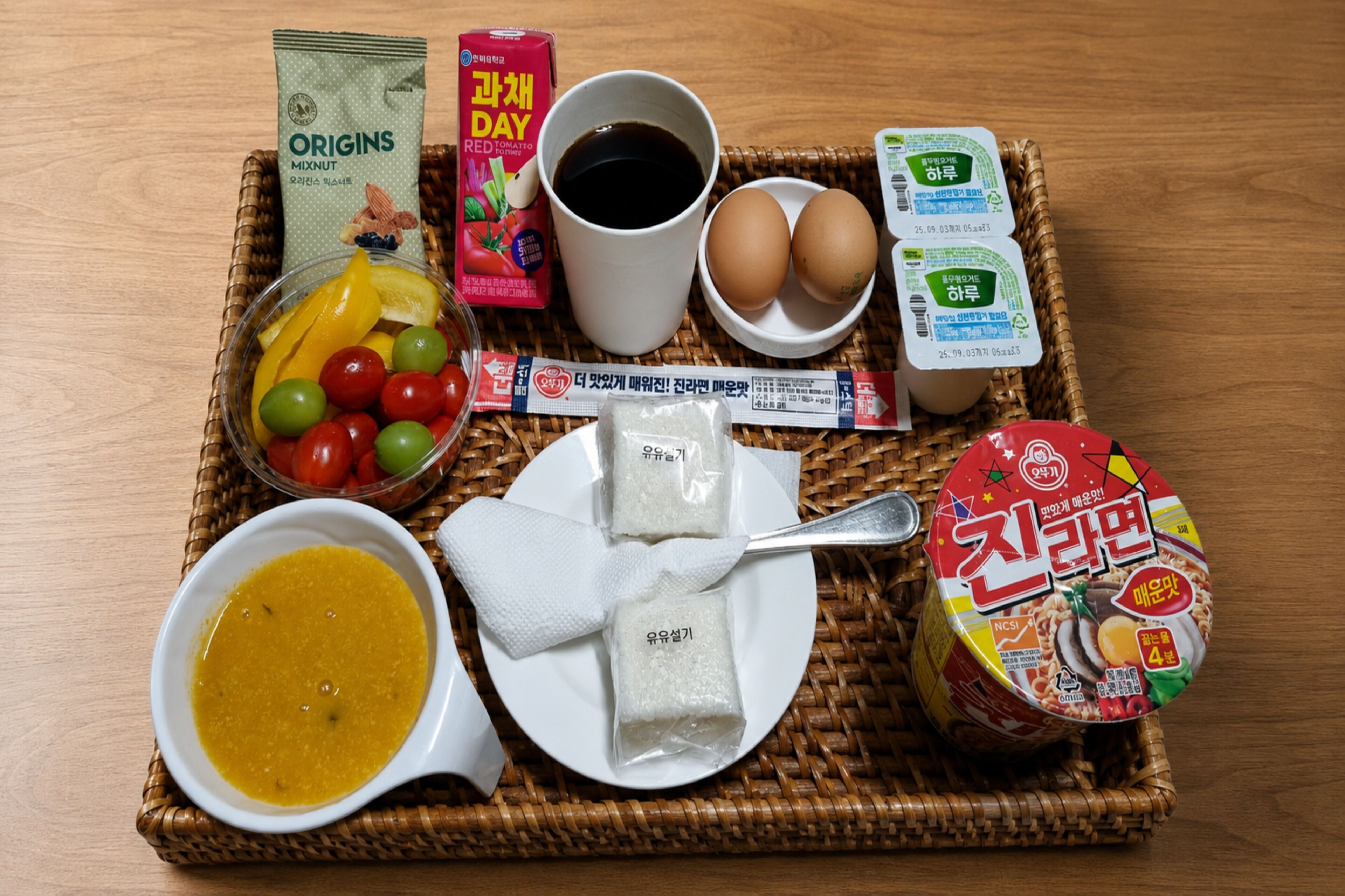 En bakke med mad, herunder en skål suppe, en tallerken med ris, æg og en kop kaffe.