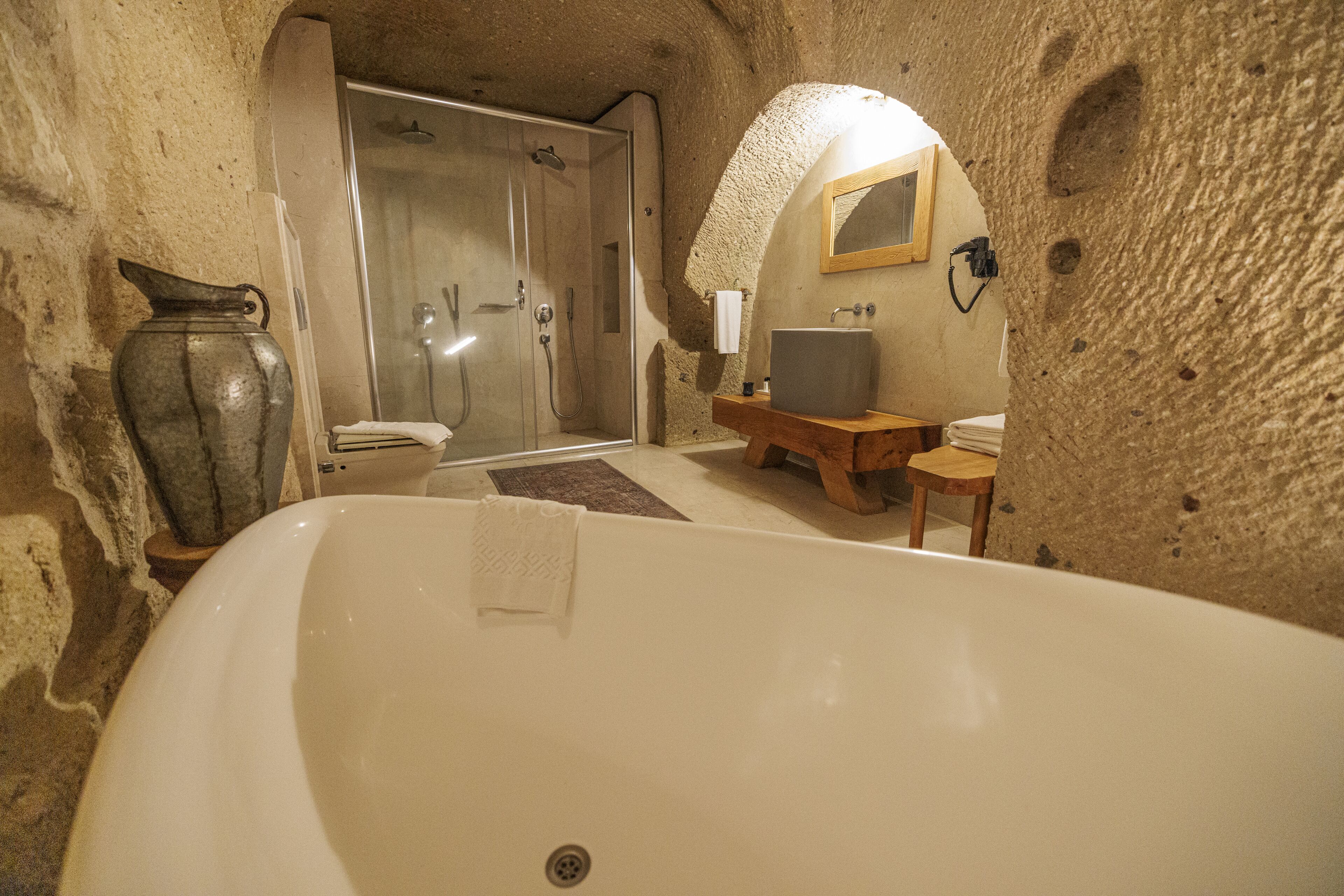 A bathroom with a large bathtub, a shower, and a sink.