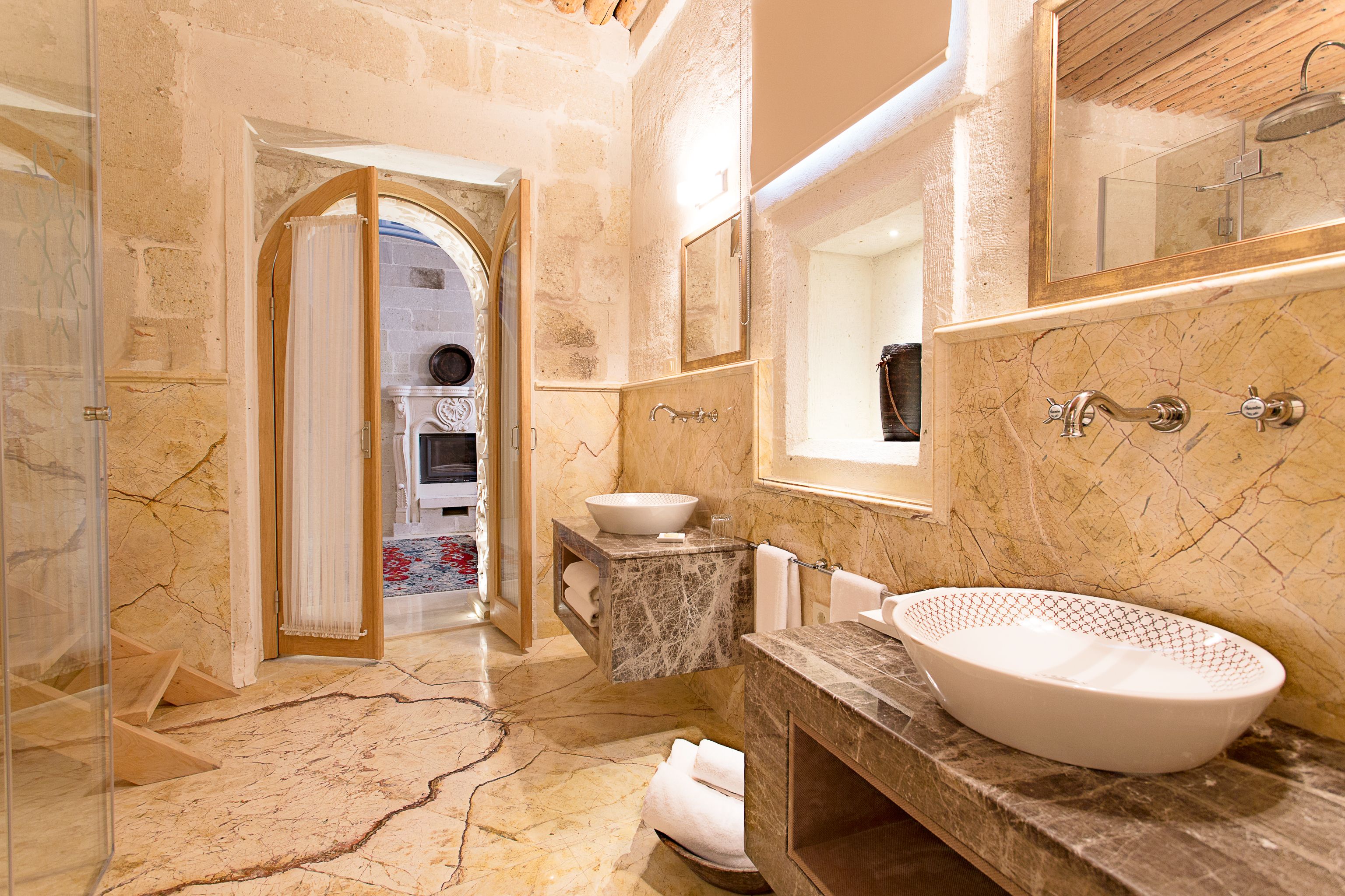 A luxurious bathroom with a large marble sink, a built-in bathtub, and a separate shower area.