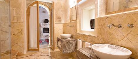 A luxurious bathroom with a large marble sink, a built-in bathtub, and a separate shower area.