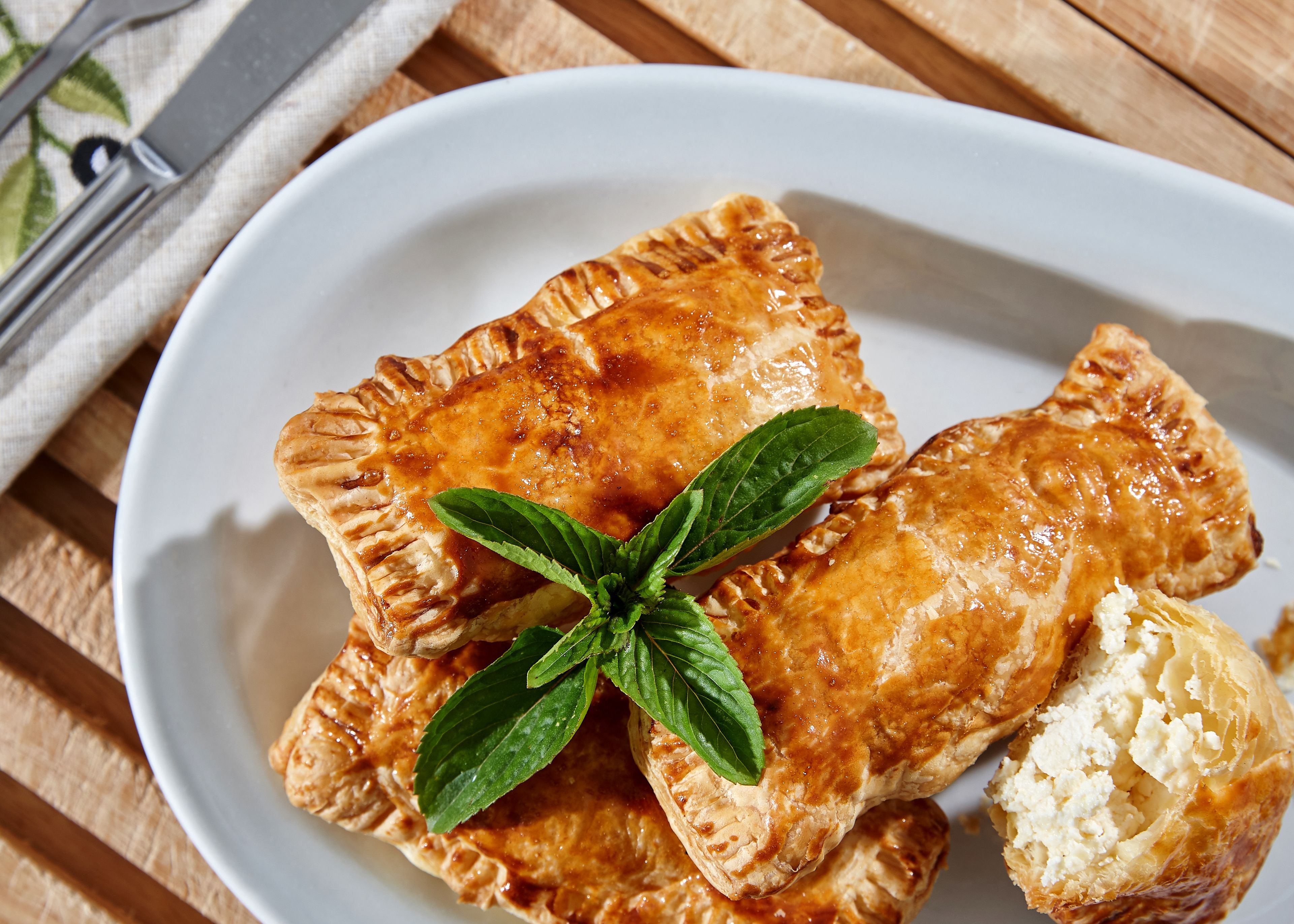 A plate of pastries with a mint leaf garnish.