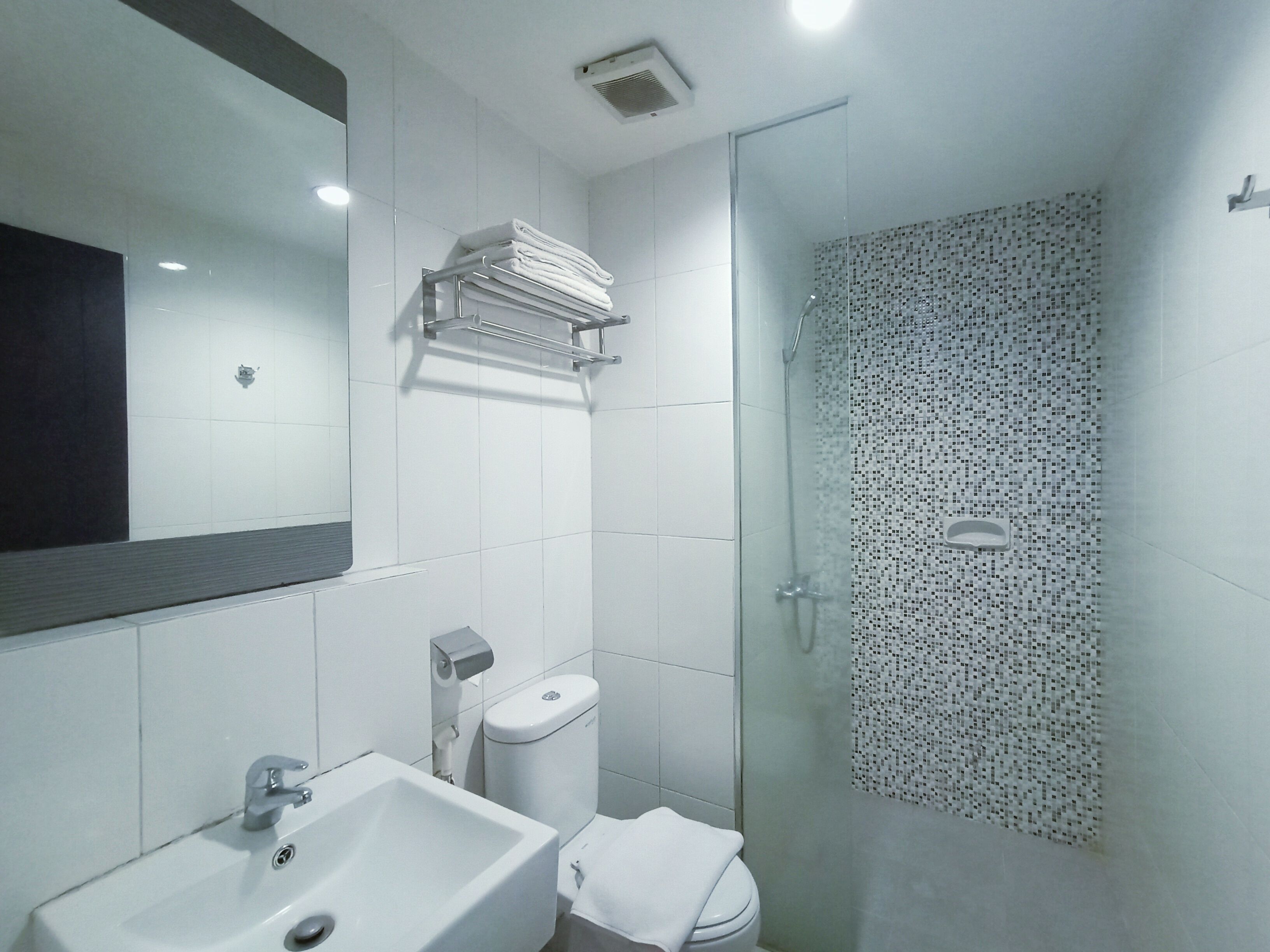 A modern bathroom with a sink, toilet, and glass shower enclosure.