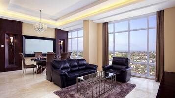 A modern living room with a large window, a chandelier, and a dining area.