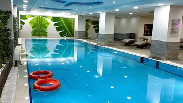 Una piscina techada, sillones reclinables de piscina