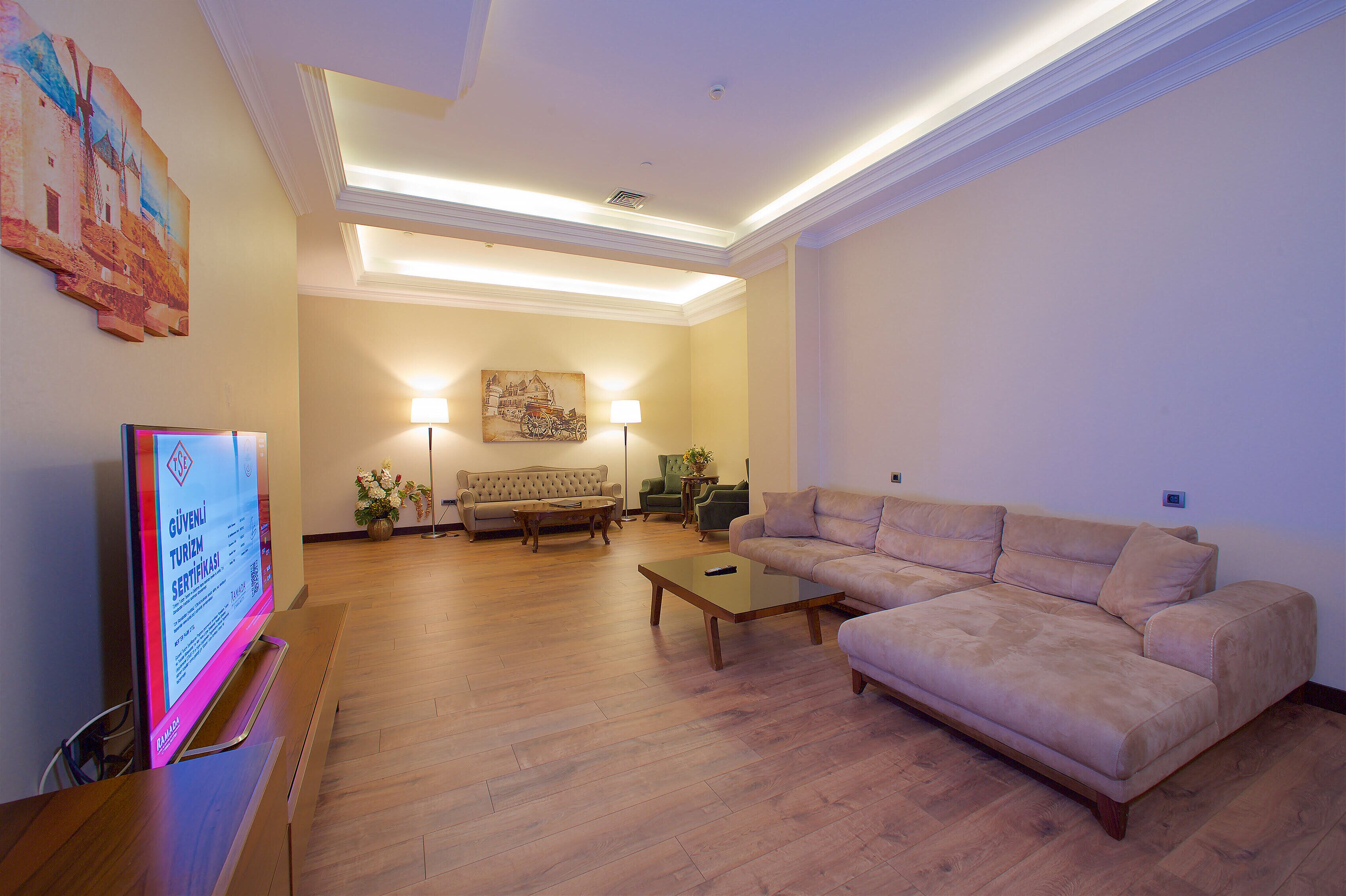 A spacious living room with a sofa, a coffee table, and a TV on a stand.