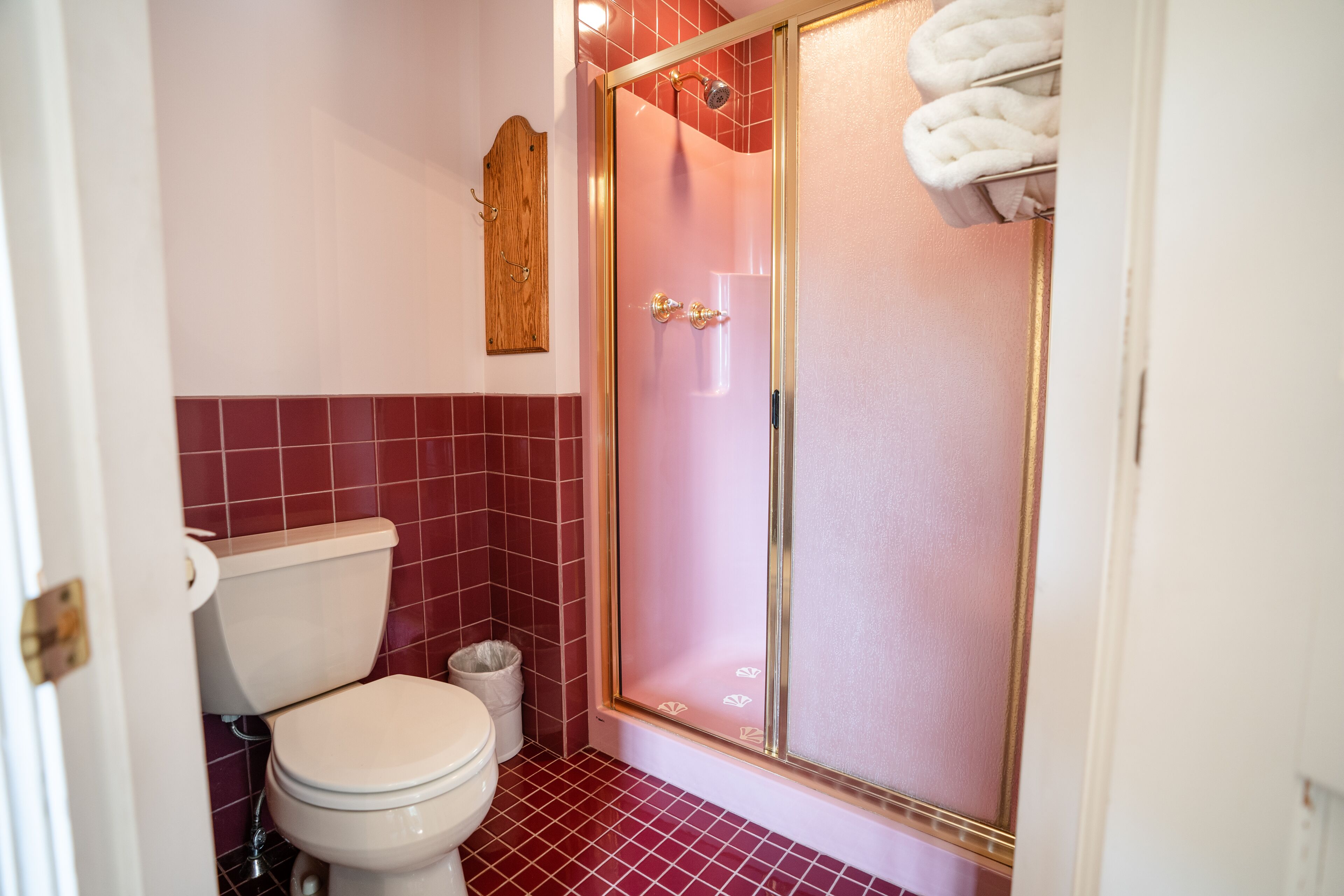 Un baño con inodoro, ducha con puerta de cristal y barra para toallas.