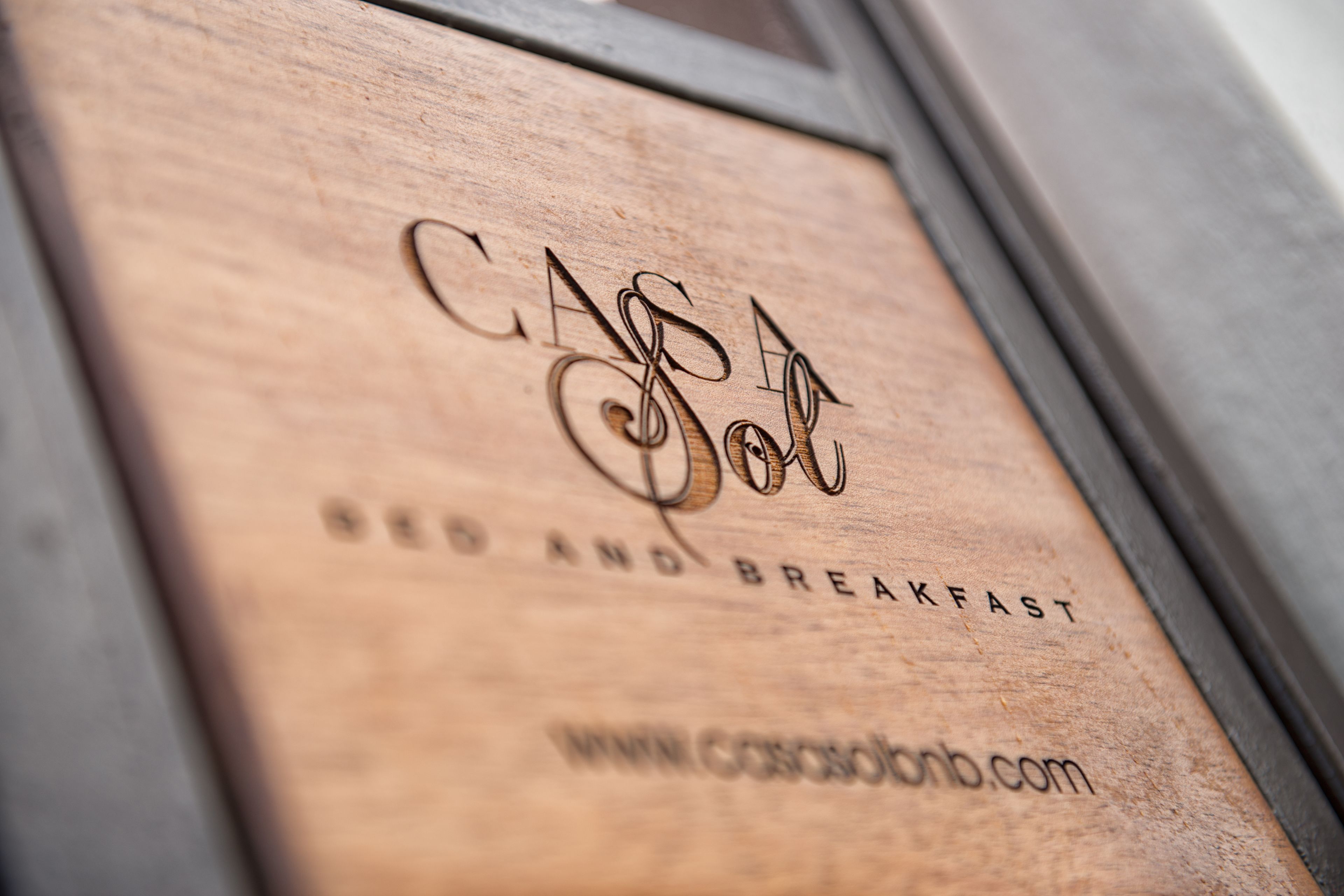 A wooden sign with the text "CASA" and "BED AND BREAKFAST" indicating the establishment's name and services.