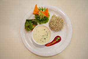 Une assiette de riz, de légumes et un bol de soupe.