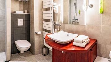 Ein modernes Badezimmer mit Toilette, Waschbecken, Dusche und Spiegel.