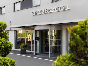 Entrada de hotel con un cartel que dice 'Mercure Hotel'.