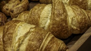Una bandeja con varios pasteles y bollos, entre ellos croissants y productos con cobertura de chocolate, probablemente en una panadería o cafetería.
