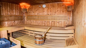 Una sauna de madera con bancos y un balde.