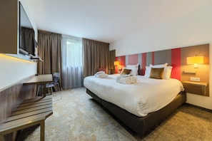 A hotel room with a large bed, a desk, a chair, and a TV. - Mercure Belfort Centre (Belfort)