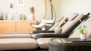 A room with a sofa, a hanging chair, a small table with a plant, and a cabinet with decorative items. - Mercure Belfort Centre (Belfort)