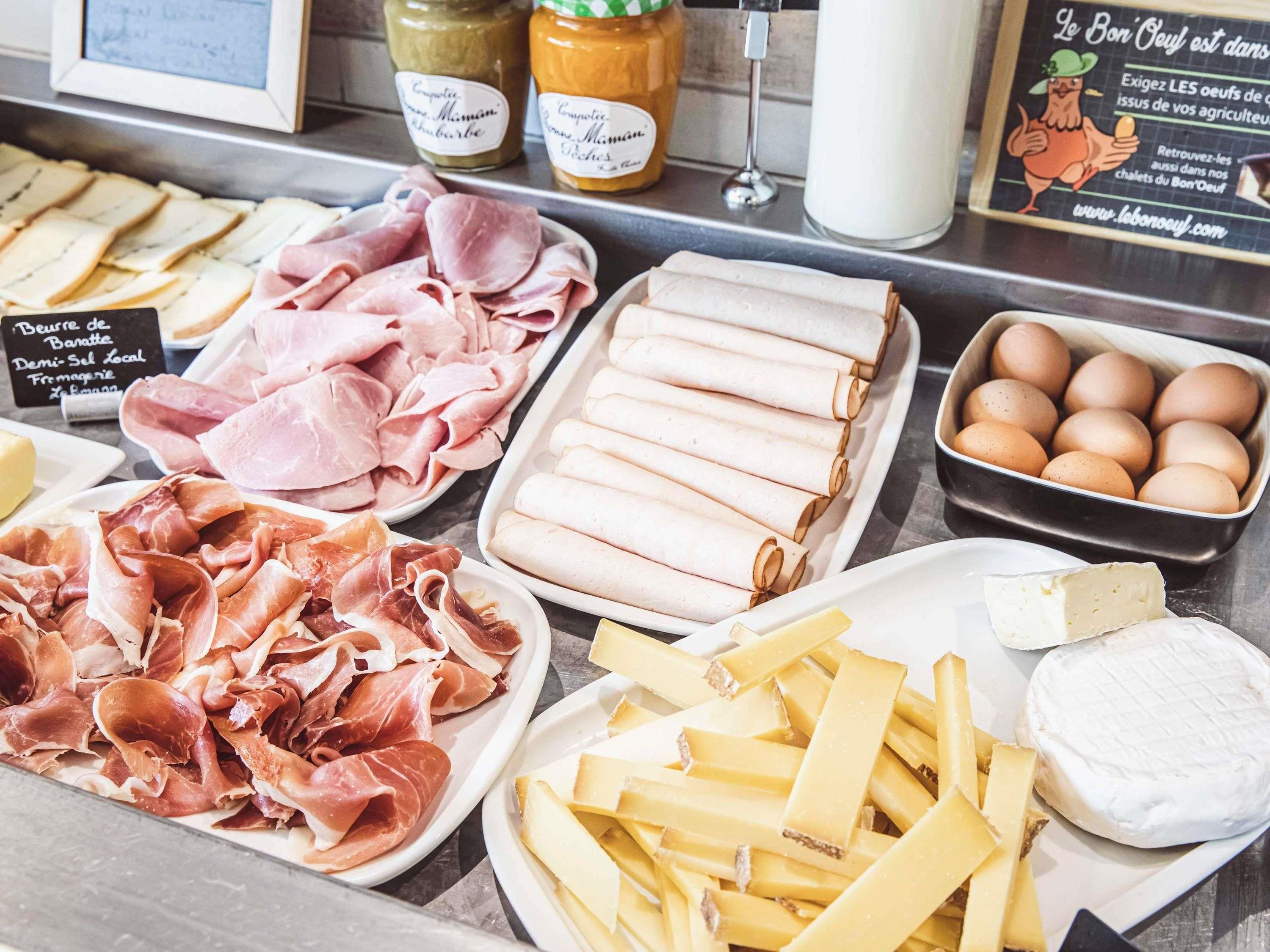 A variety of food items including meats, cheeses, and eggs displayed on a counter.