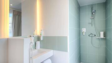 Un baño con lavamanos, espejo y ducha.