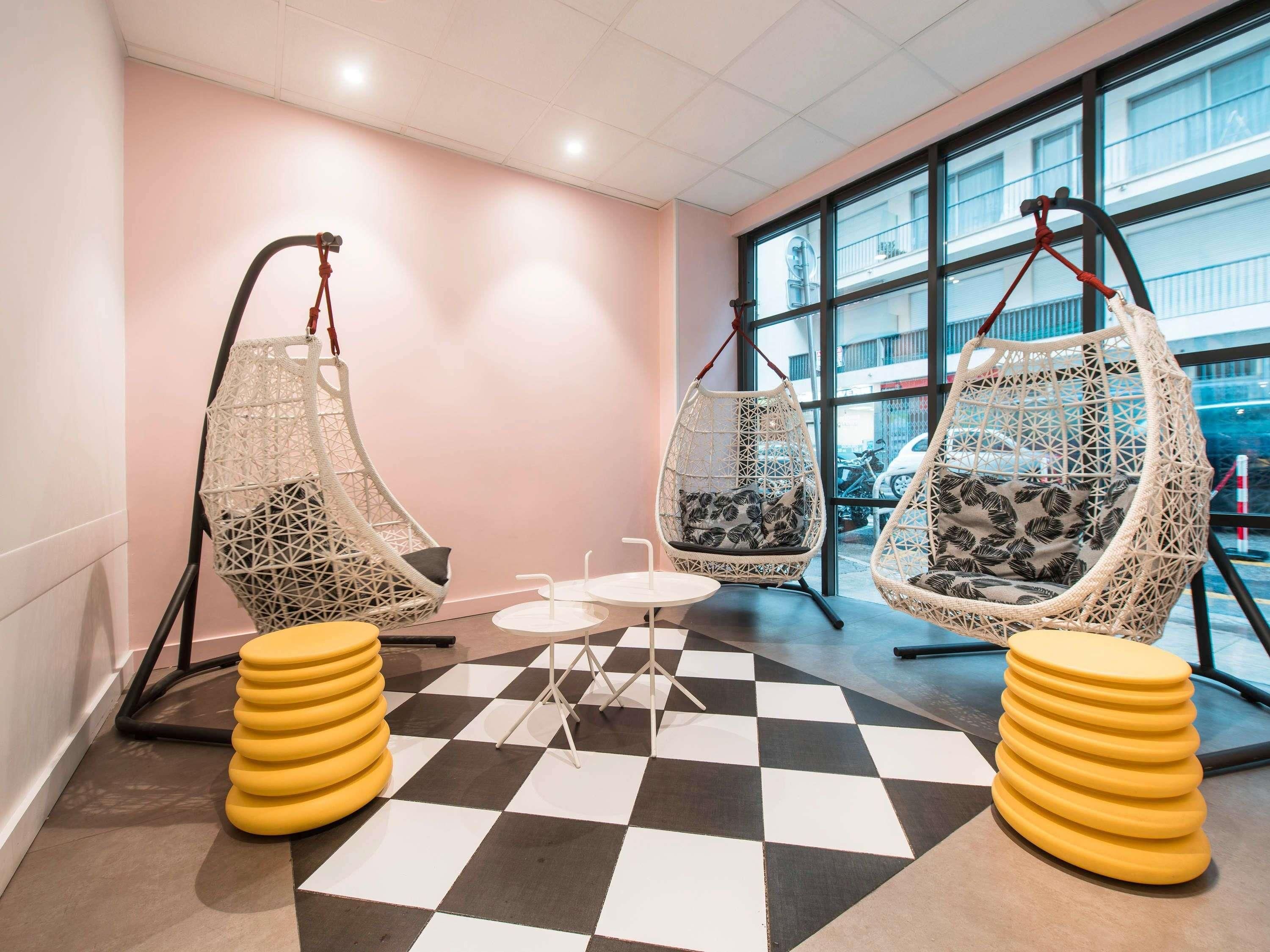 A room with two hanging chairs, a small table, and a checkered floor.