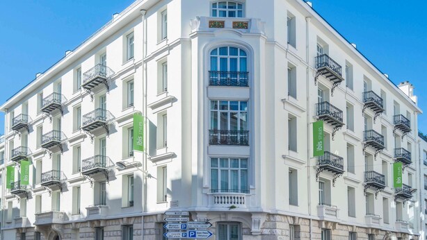 A multi-story building with a classic architectural style, featuring balconies and a central entrance with a large arched window. - Ibis Styles Nice Centre Gare (Nice)