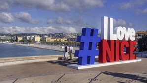 A large outdoor sign with the text "I Love Nice" in bold letters, set against a backdrop of a coastal cityscape with buildings and a clear sky. - Ibis Styles Nice Centre Gare (Nice)