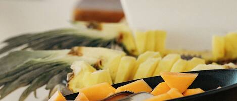 A fruit platter with pineapple, cantaloupe, and other fruits on a table.