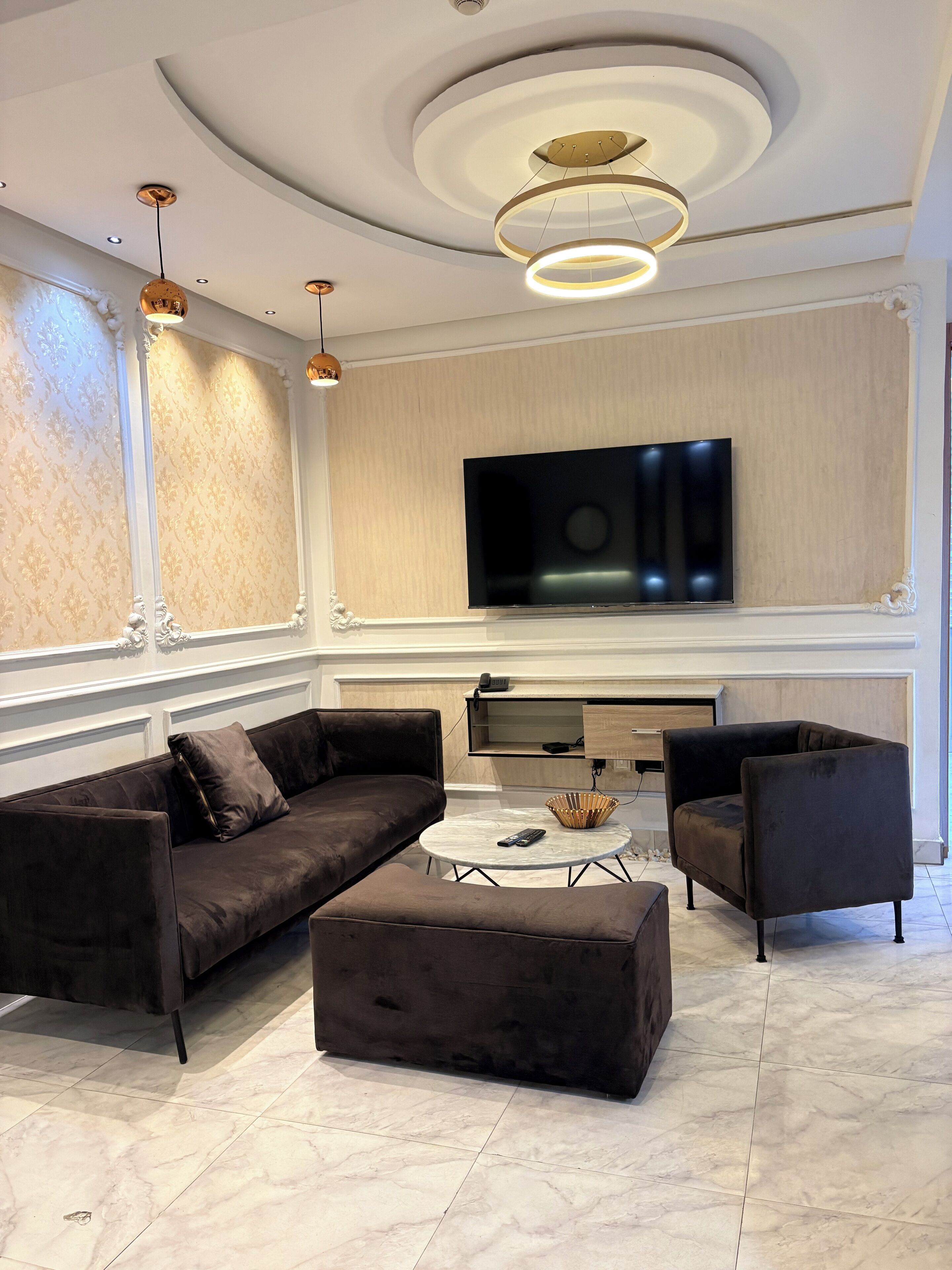 A modern living room with a sectional sofa, a coffee table, and two armchairs.