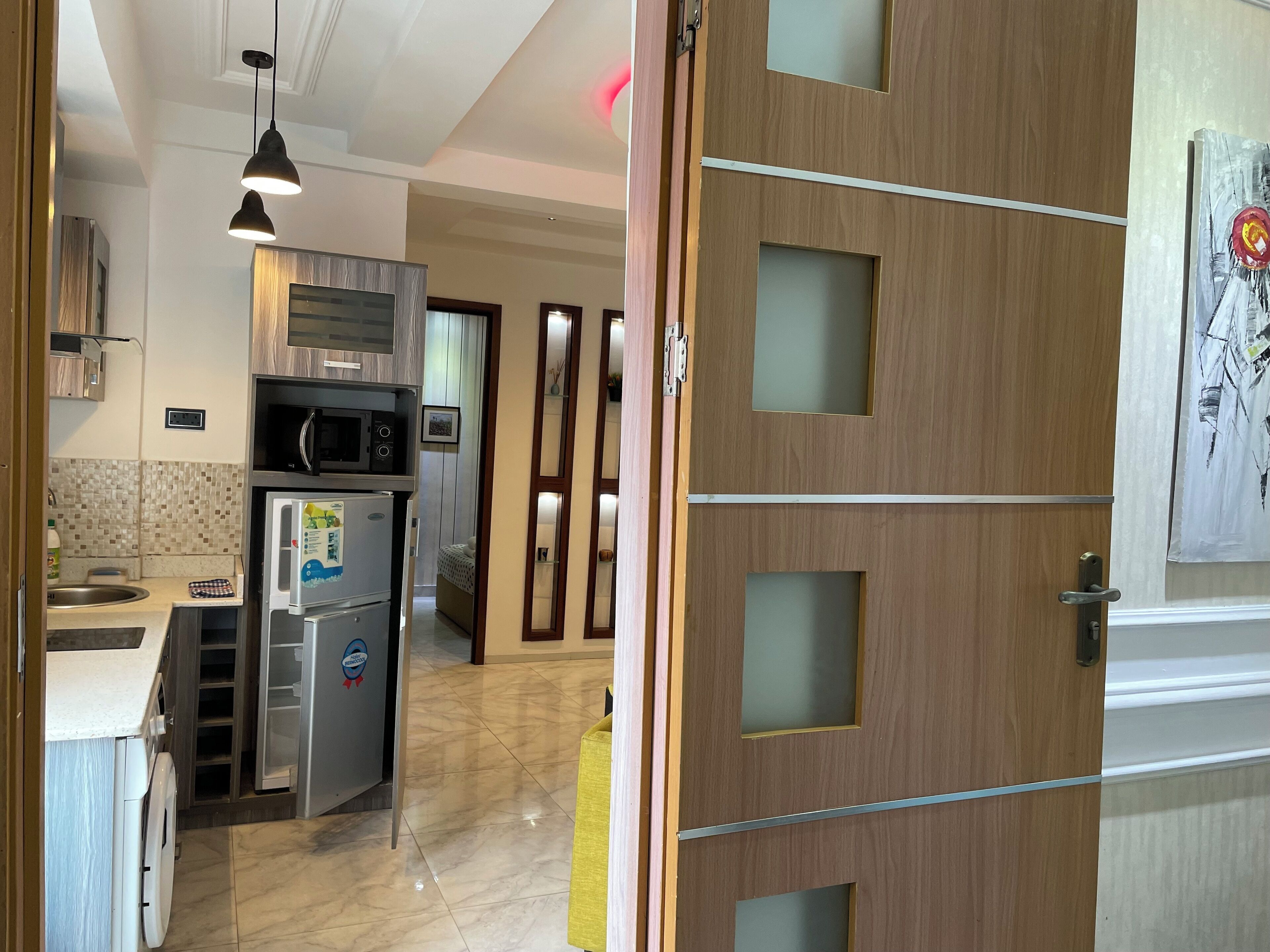 Una cocina moderna con microondas, refrigerador y lavaplatos.