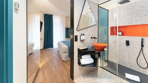 Un baño moderno con cabina de ducha de vidrio, un lavamanos independiente y un espejo grande.