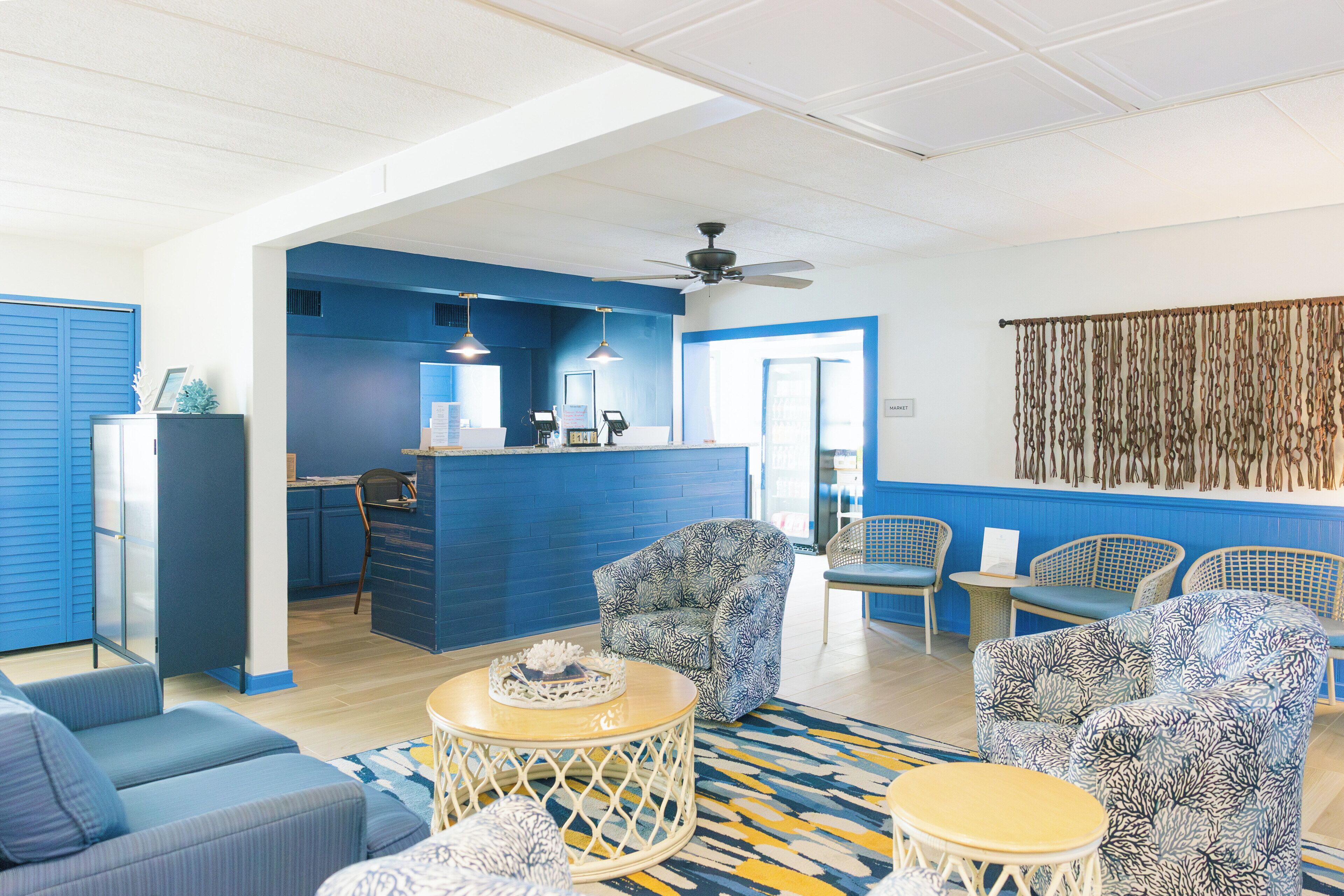 Eine Hotelhalle mit Rezeption, Sitzbereich und einer Küche im Hintergrund.