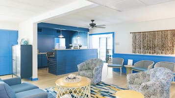 Eine Hotelhalle mit Rezeption, Sitzbereich und einer Küche im Hintergrund.