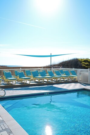A pool with blue chairs and a white fence. - Surf Side Hotel (Nags Head)