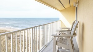 A balcony with a view of the ocean, a white railing, and two wooden chairs. - Surf Side Hotel (Nags Head)