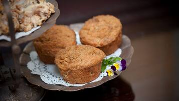 A plate with three muffins and a decorative doily.