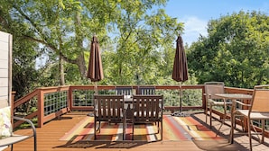 A wooden deck with a table and chairs, surrounded by trees. - Steeles Tavern Manor (Raphine)