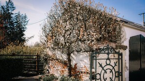 A rustic building with a brick wall and a metal gate. - Brookhall Cottages (Lisburn)