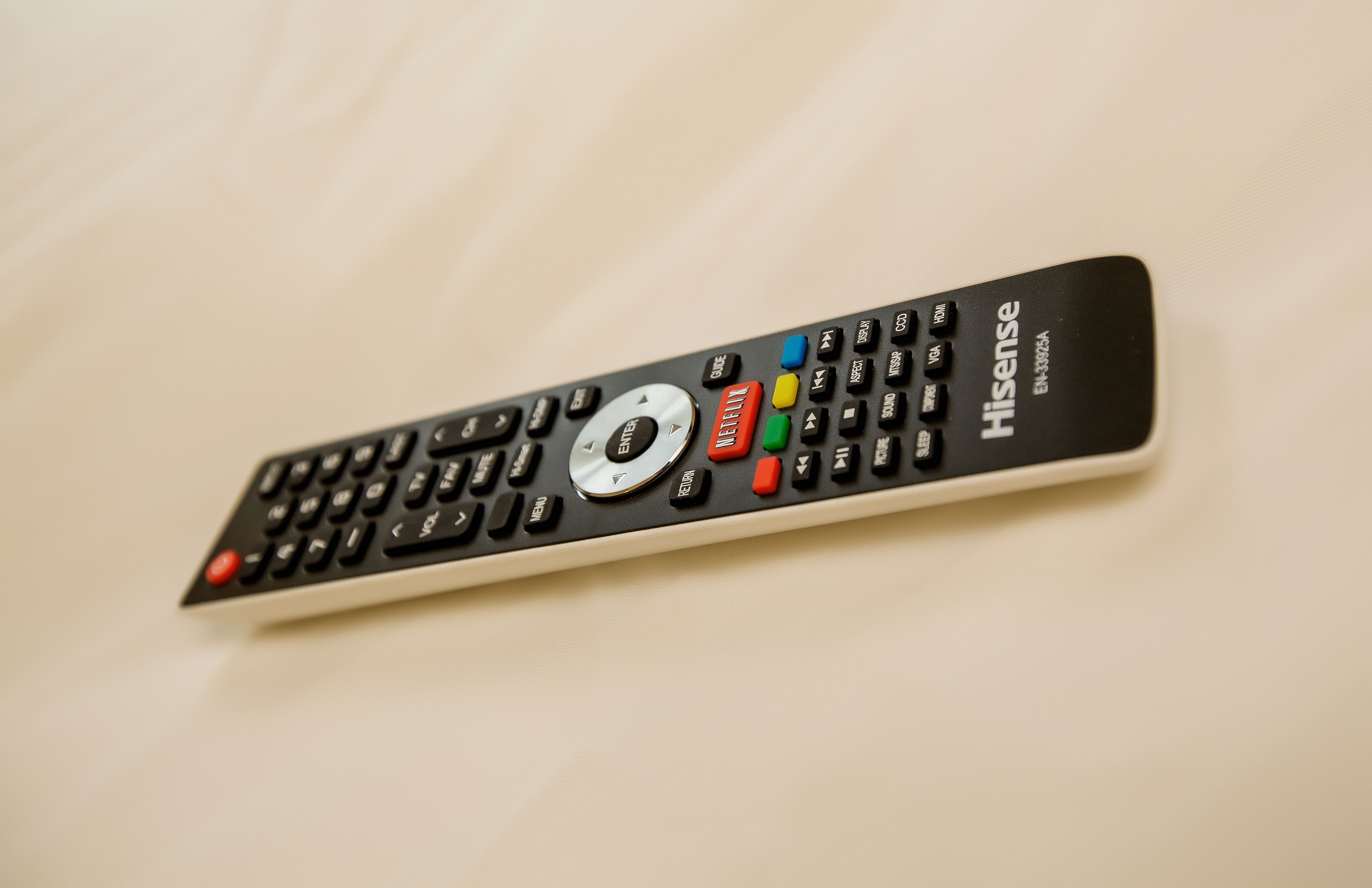 A remote control with multiple buttons and a numeric keypad.